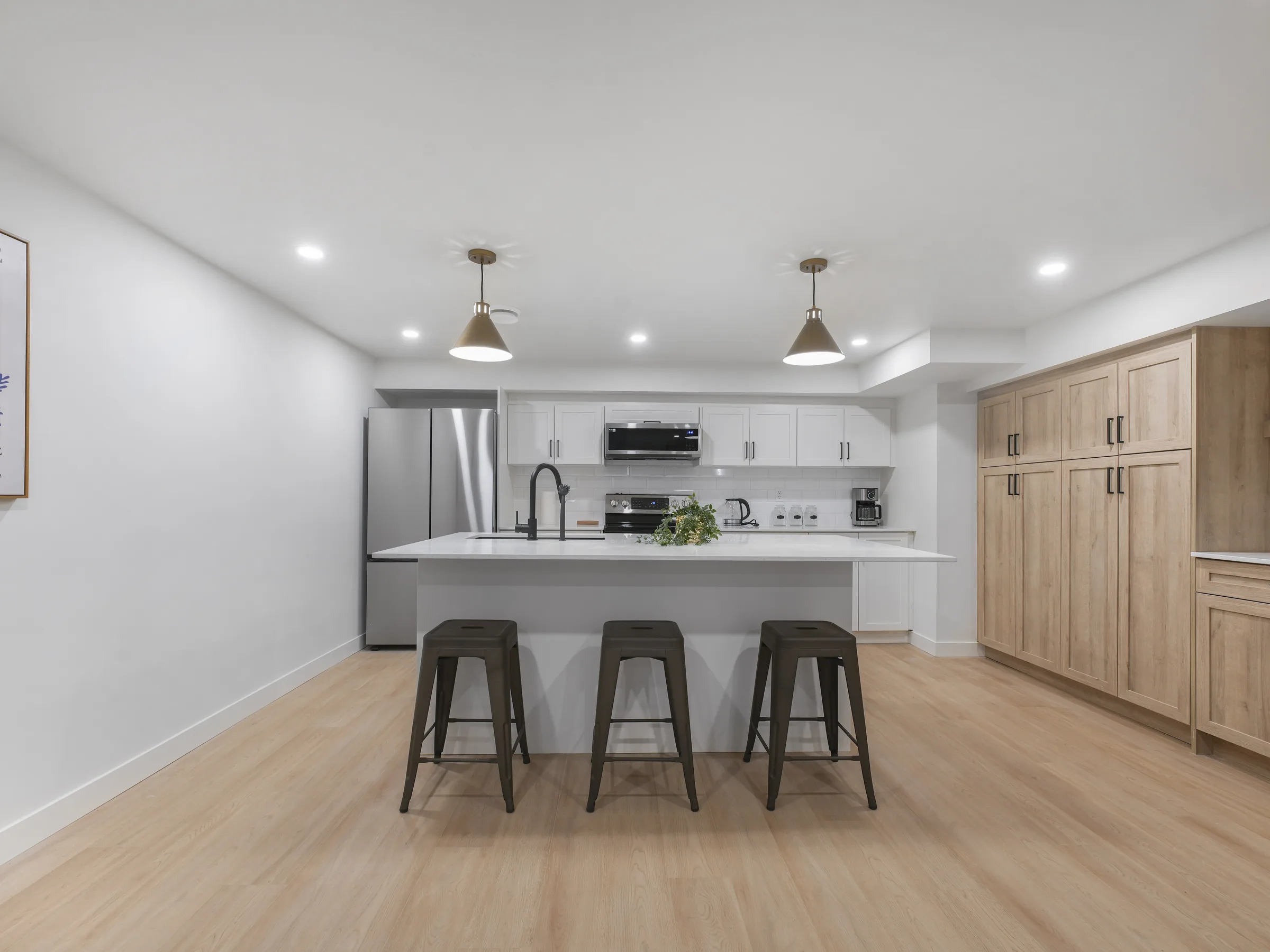 Kitchen wall shot with white cabinets, stainless range and microwave