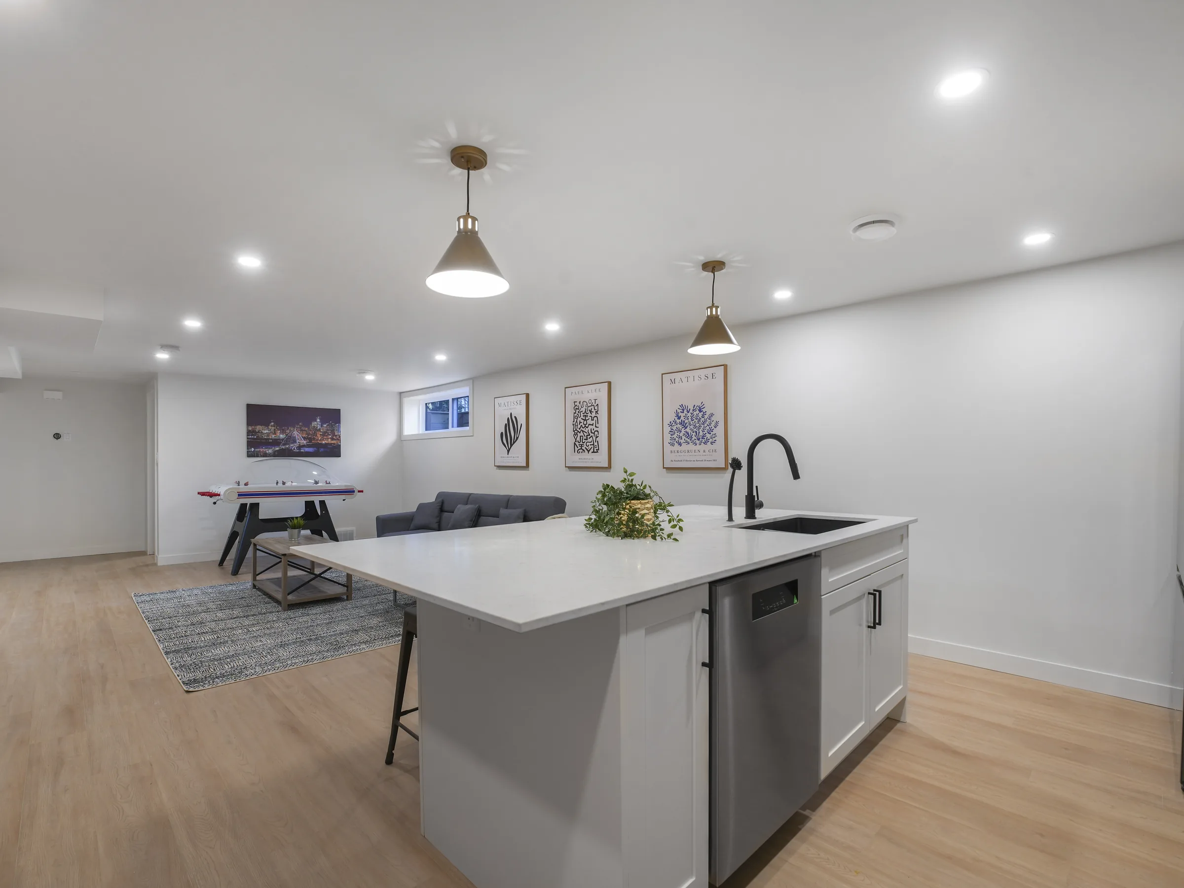 Kitchen wide angle showing the rec room and island