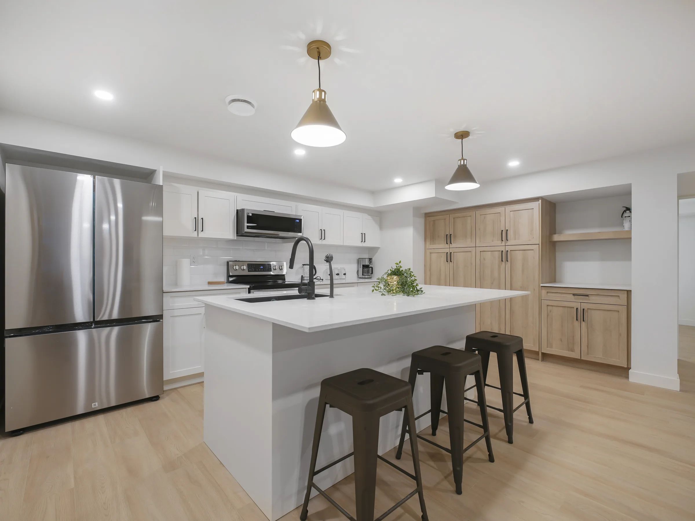 Kitchen alternate angle with stainless fridge in the foreground