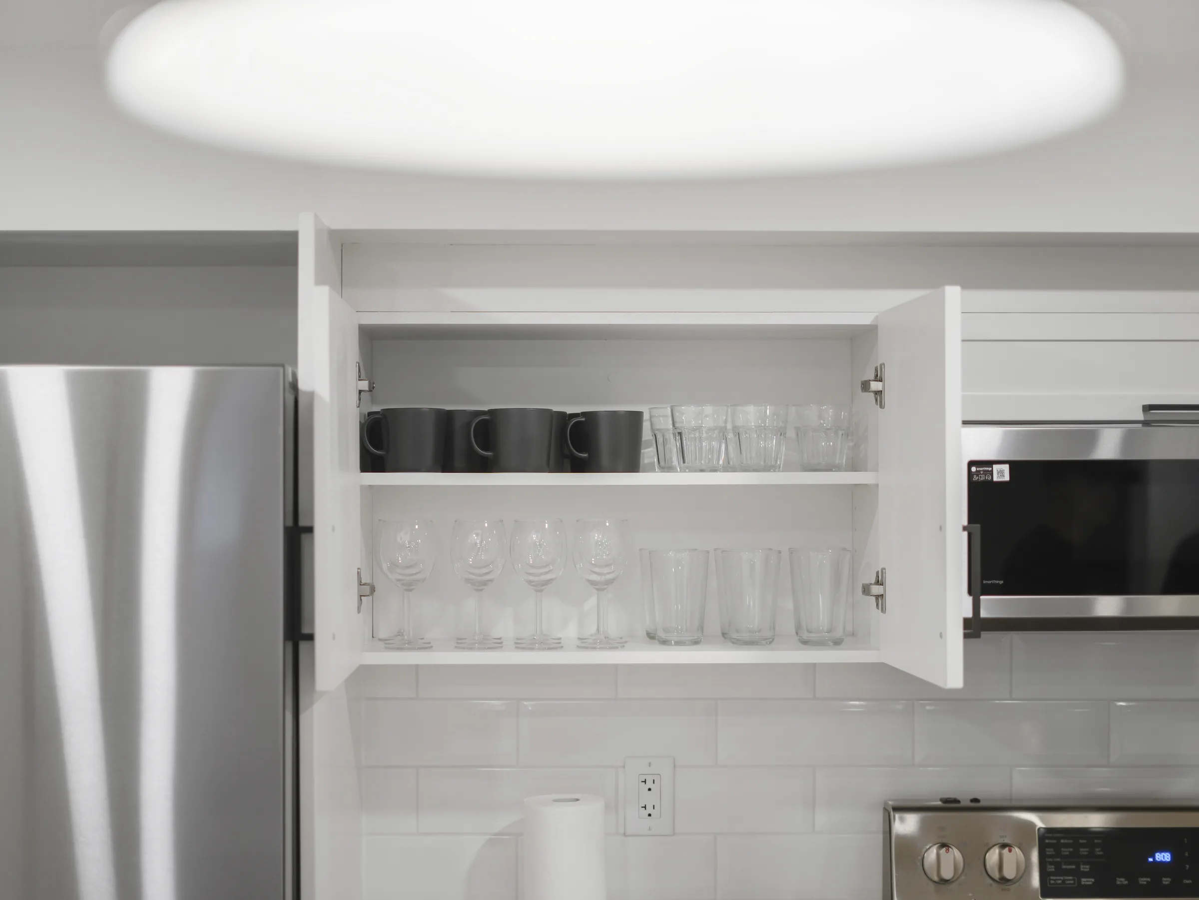 Open cabinet showing mugs and glasses