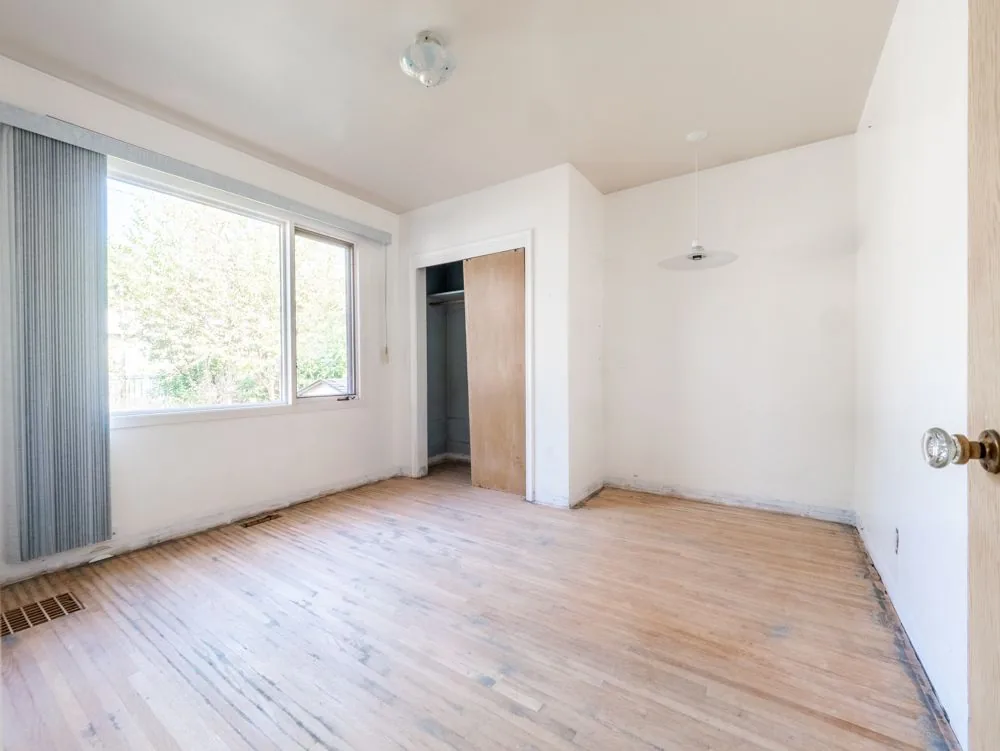 Before renovation, corner bedroom with a single closet and window