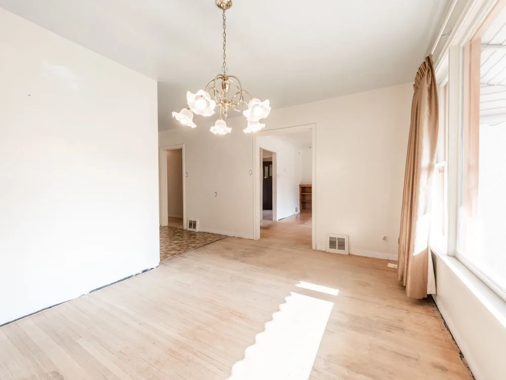 Before renovation, dining room with chandelier, opens to the kitchen