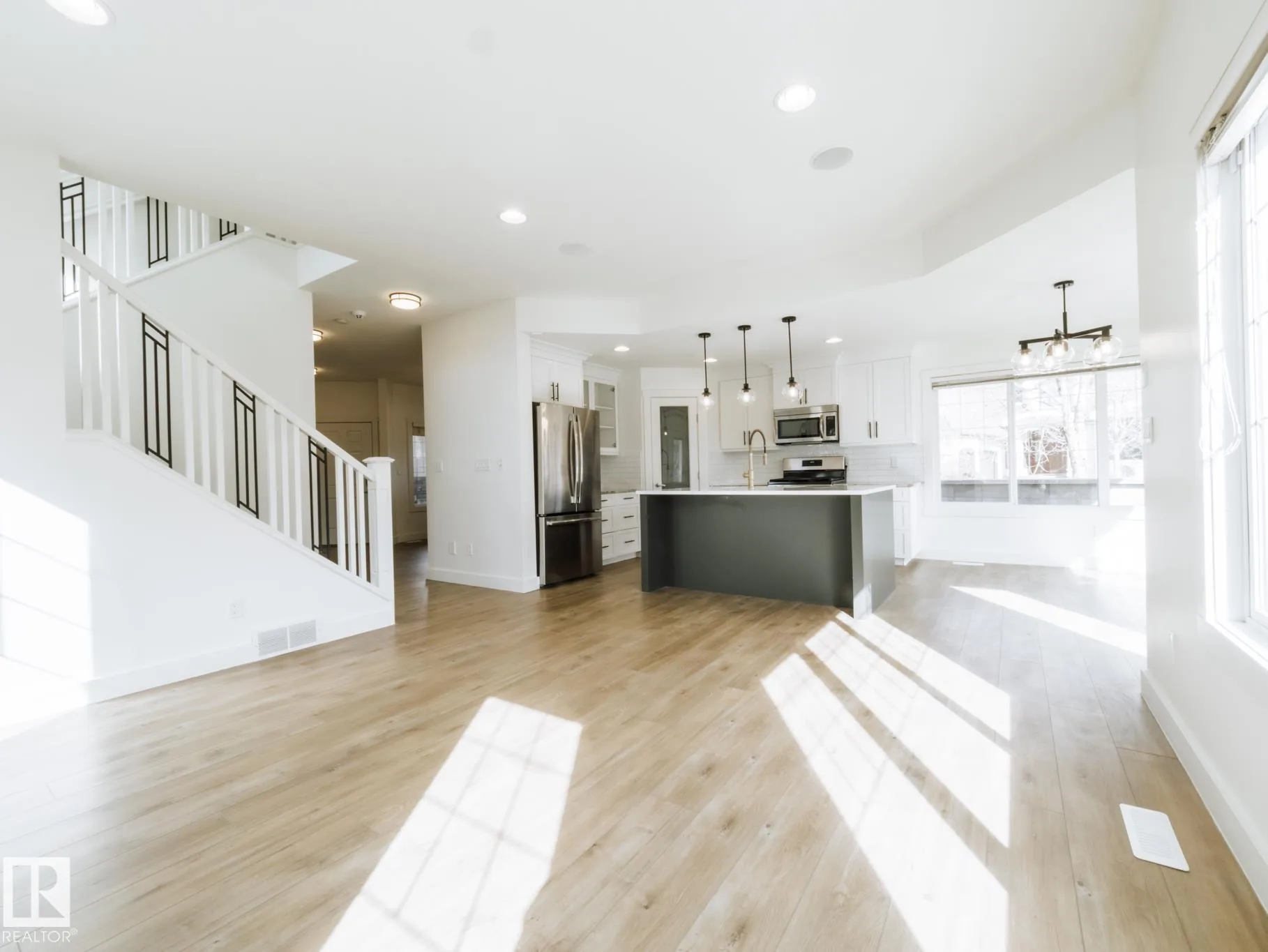 Staircase down to the front entry, white risers and black Prairie-panel balusters
