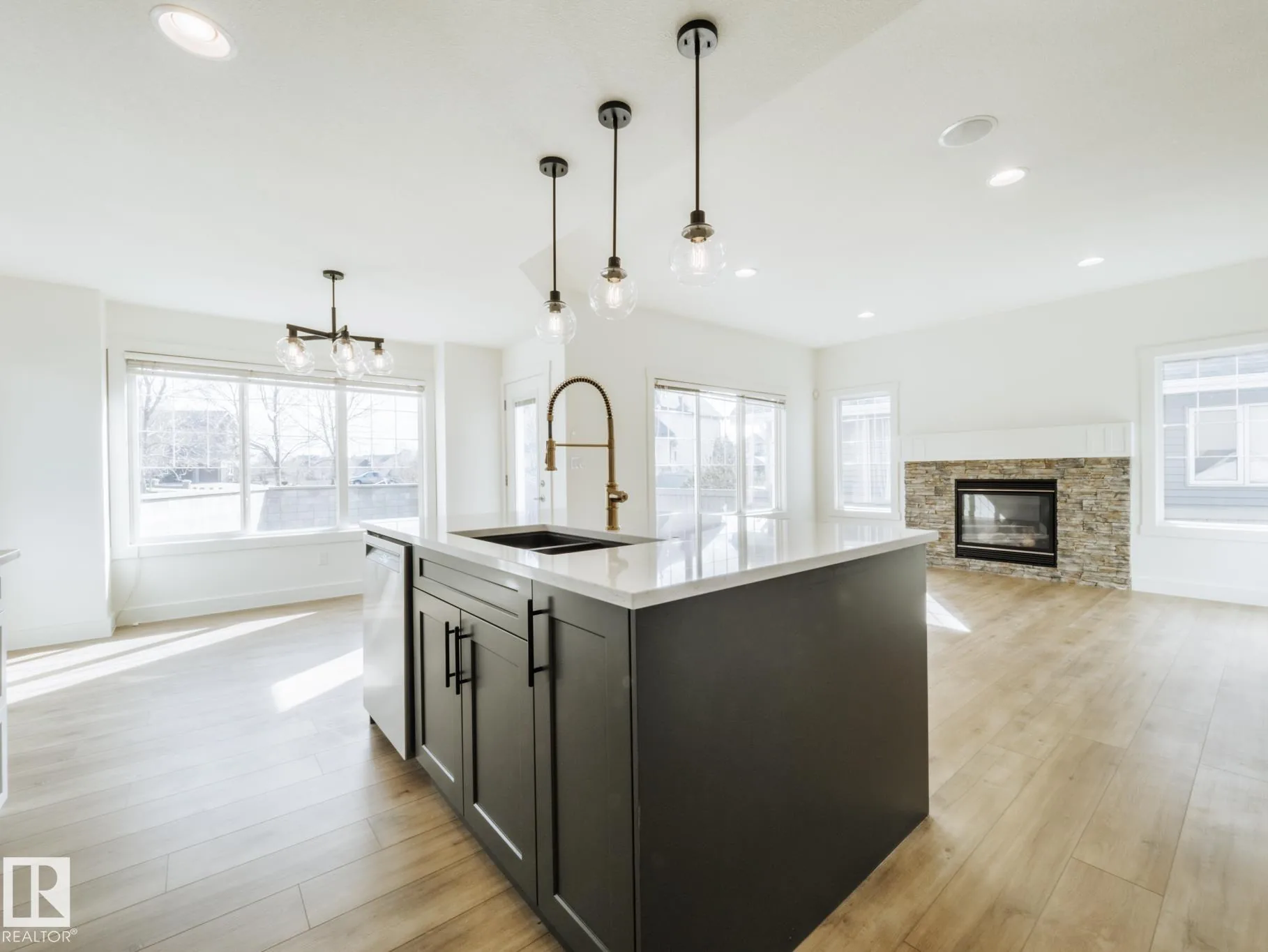 Island (dishwasher side) with the living-room fireplace visible through the open plan