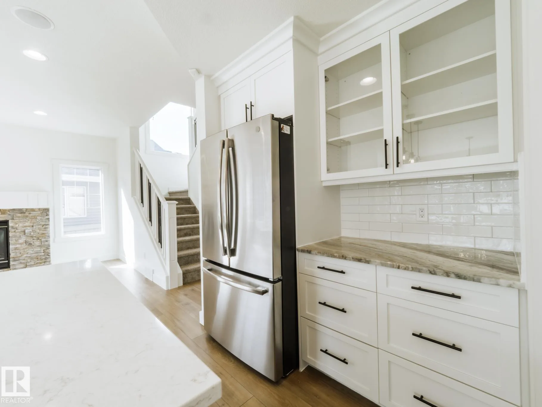 Fridge wall with the staircase and fireplace visible beyond