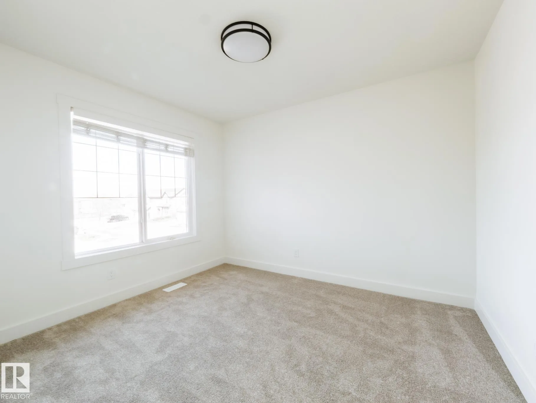 Bedroom with double bifold closet doors and a window on the adjacent wall