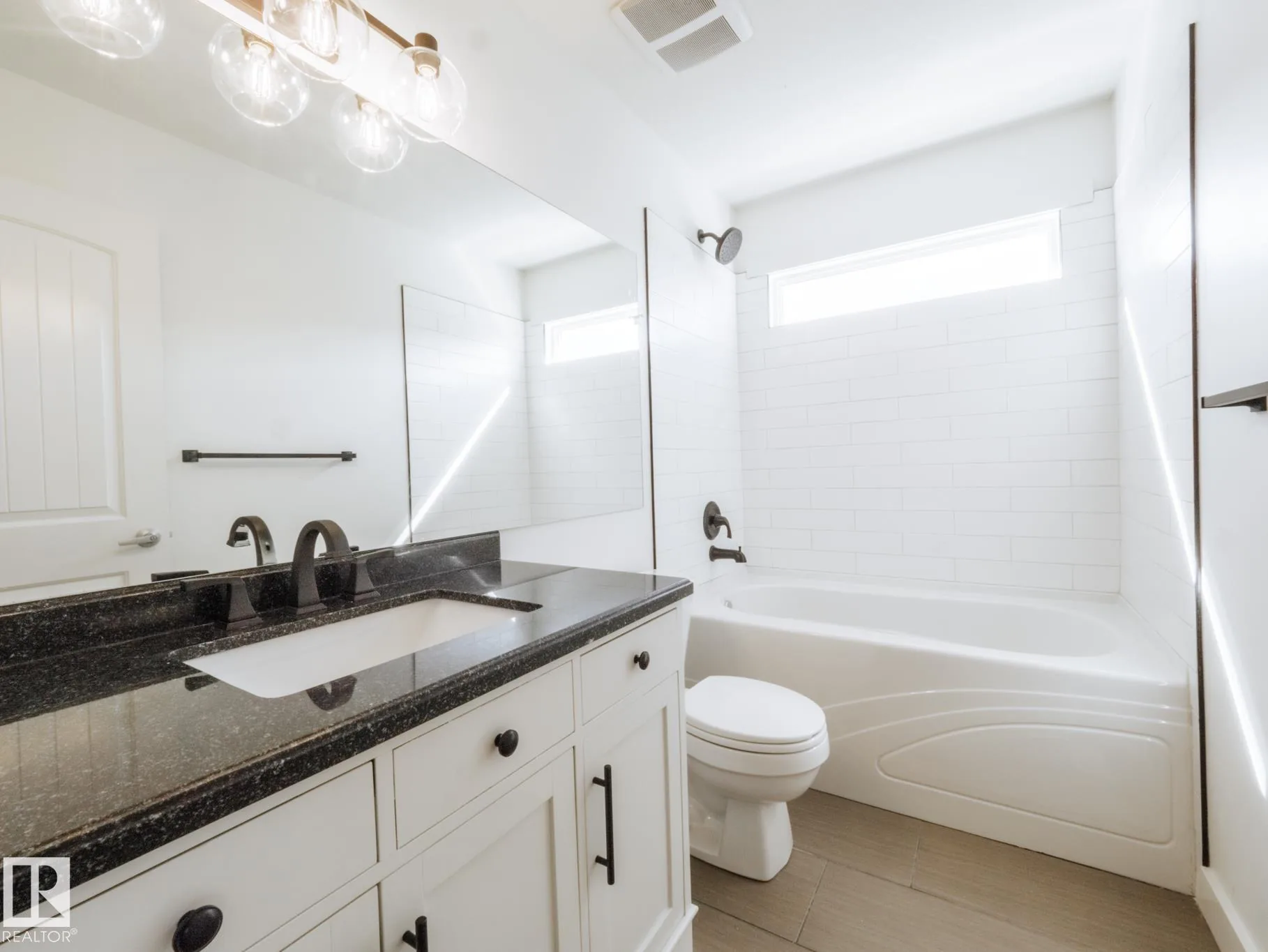 Main upstairs bath with a subway-tile tub surround and dark granite vanity