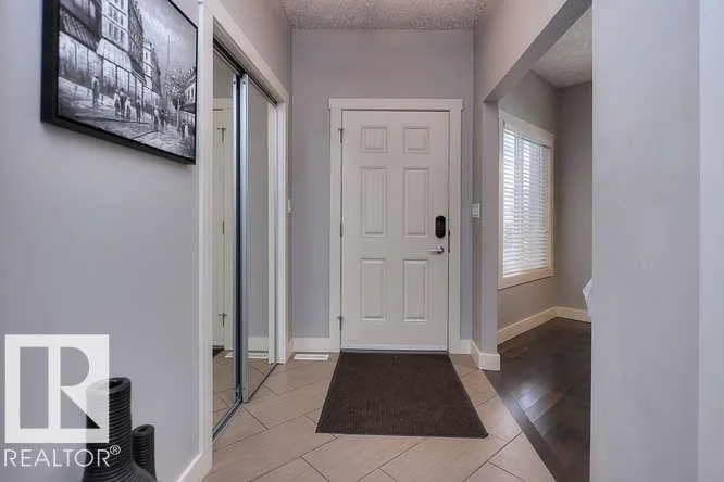 Before renovation, front foyer with a mirrored sliding closet and dark front door