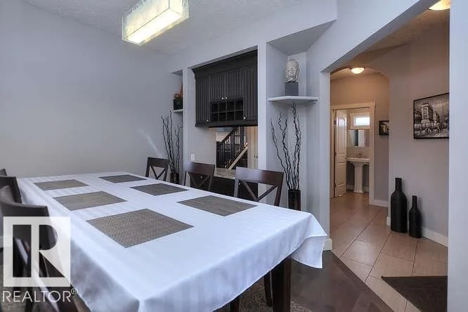 Before renovation, dining with a built-in dark display niche and an arched opening to the entry