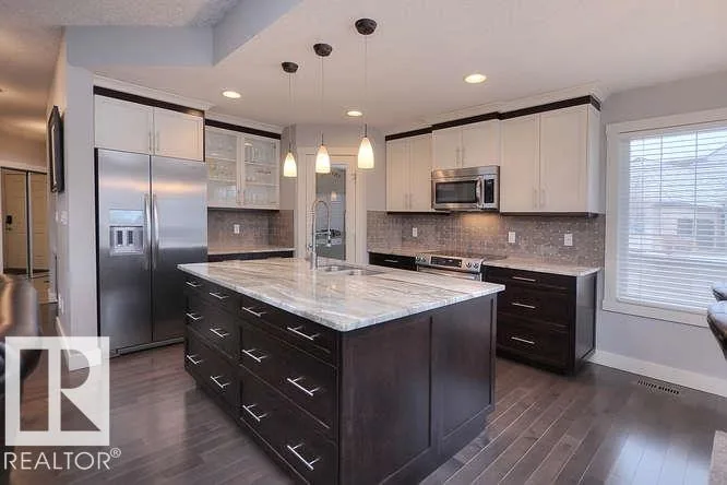 Before renovation, wide kitchen with two-tone white and espresso cabinets