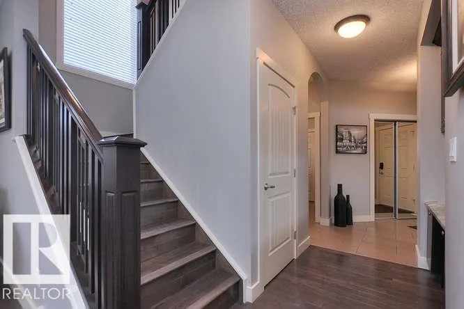 Before renovation, staircase and arched hall opening from the main-floor landing