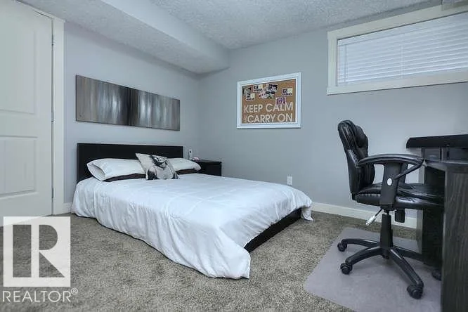 Before renovation, basement bedroom with a desk and high horizontal window