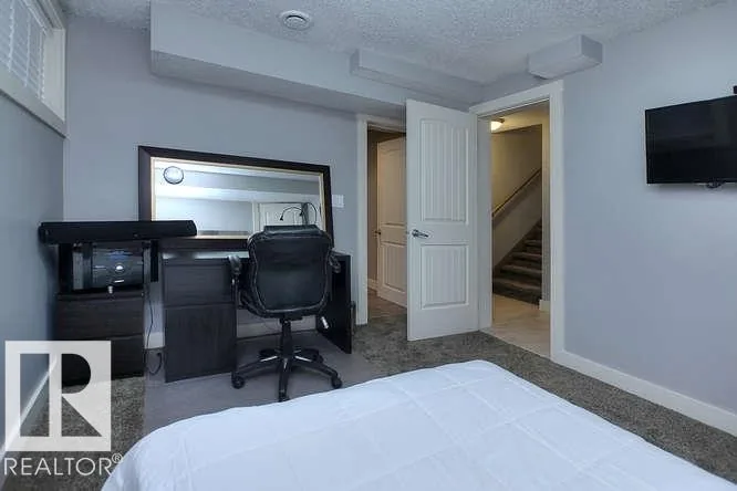 Before renovation, basement bedroom corner with view through the door to the stairs