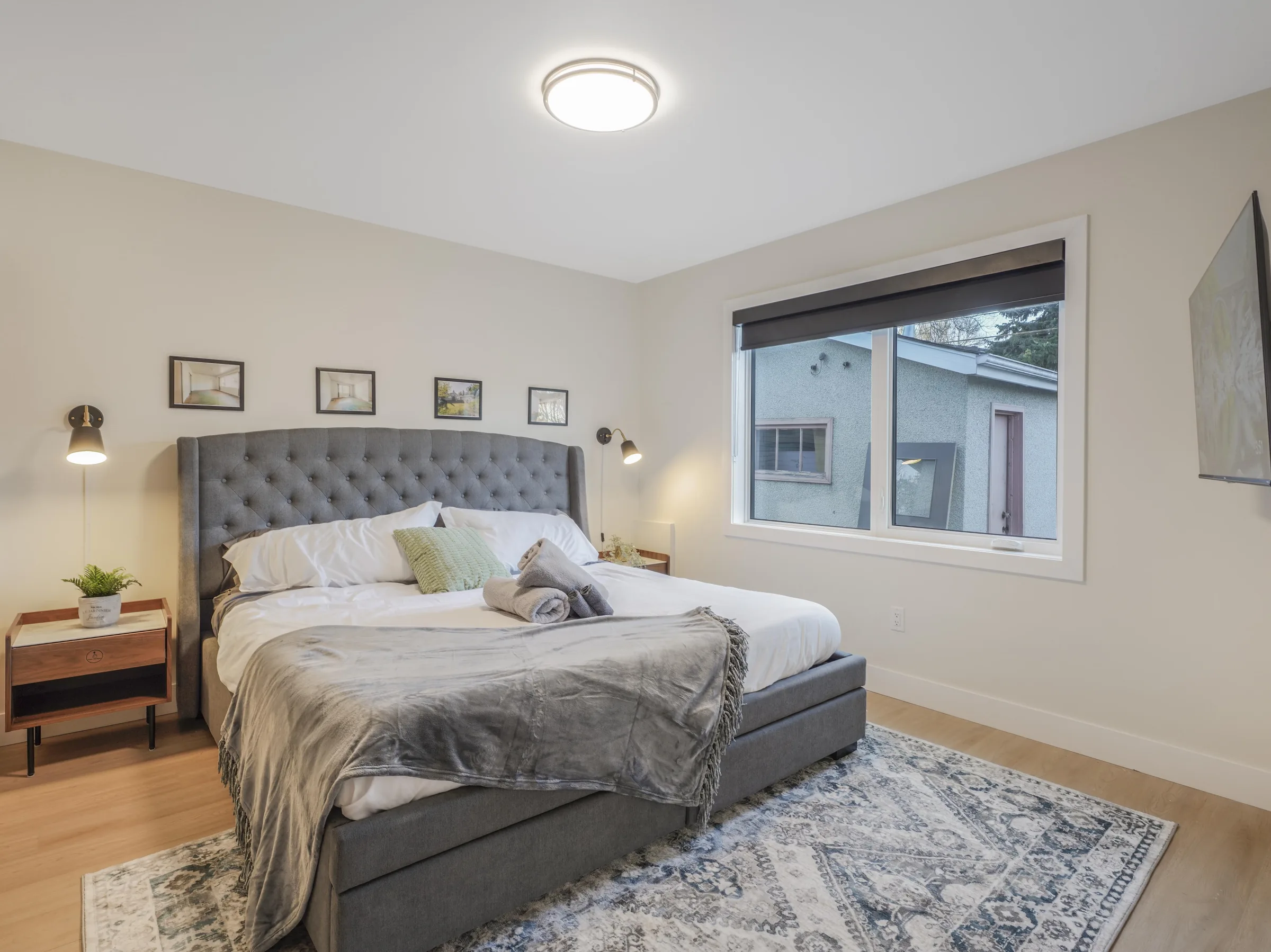 King bed with tufted headboard beneath a single window