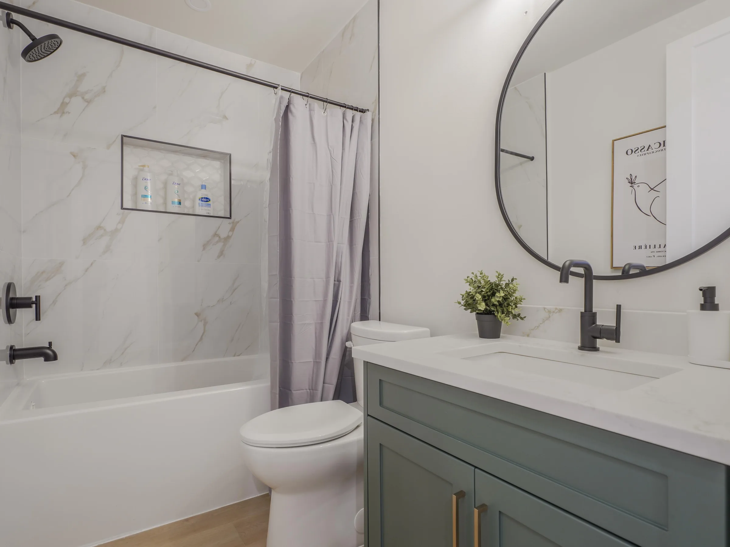 Shared bathroom with green vanity and tub/shower