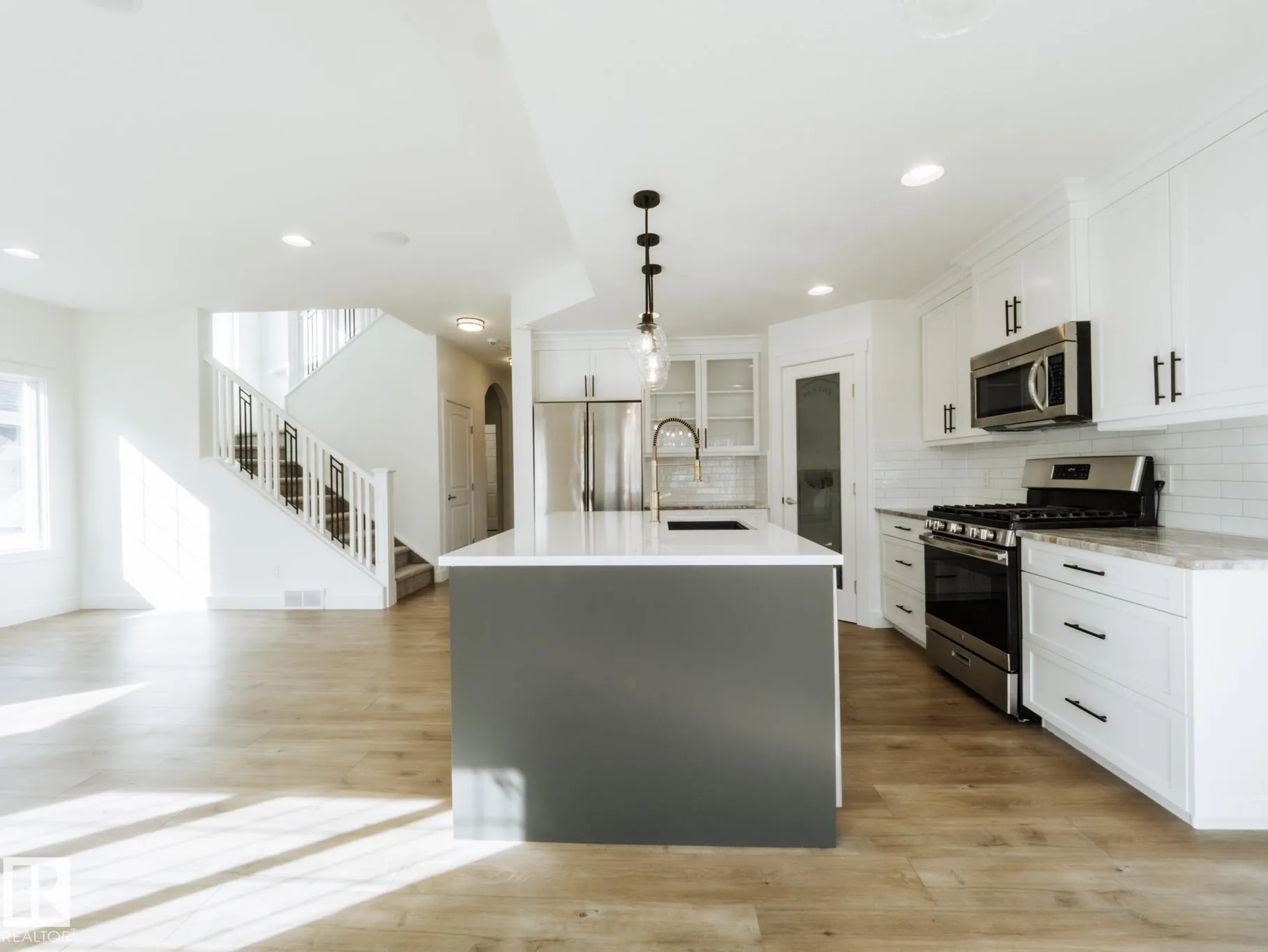 Kitchen island across the open plan, staircase visible behind