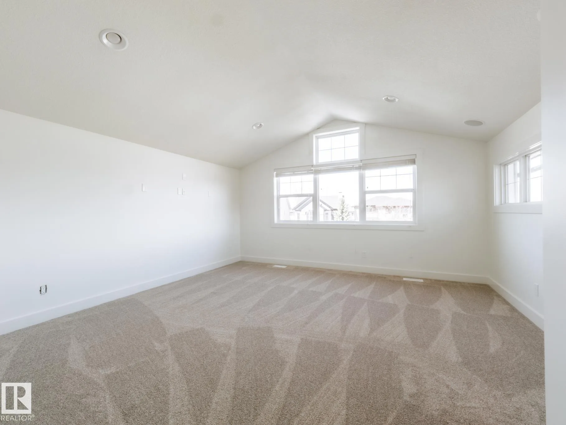 Bonus room with a vaulted ceiling and a triangular gable-peak window