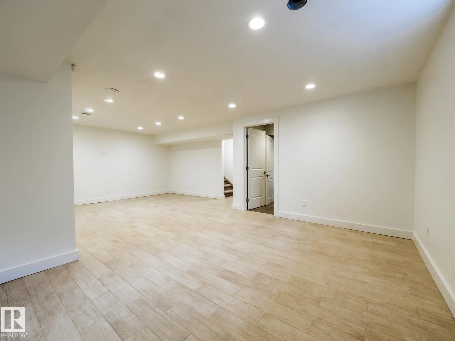 Basement family room, heated tile floors, staircase to the main floor beyond